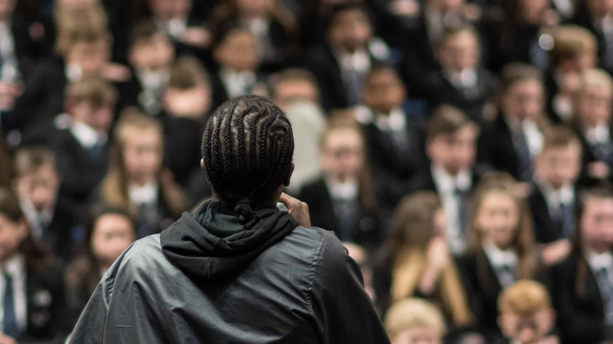 a person in a black jacket looking at a crowd of people