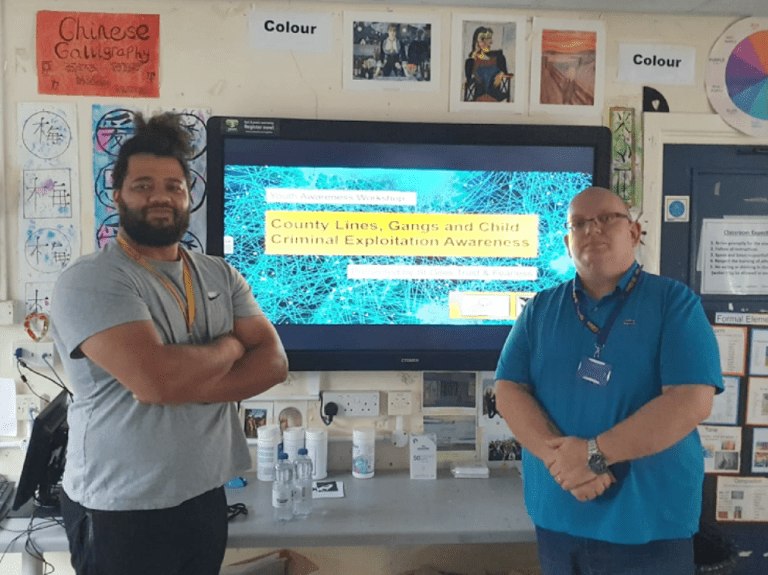 two men standing in front of a television