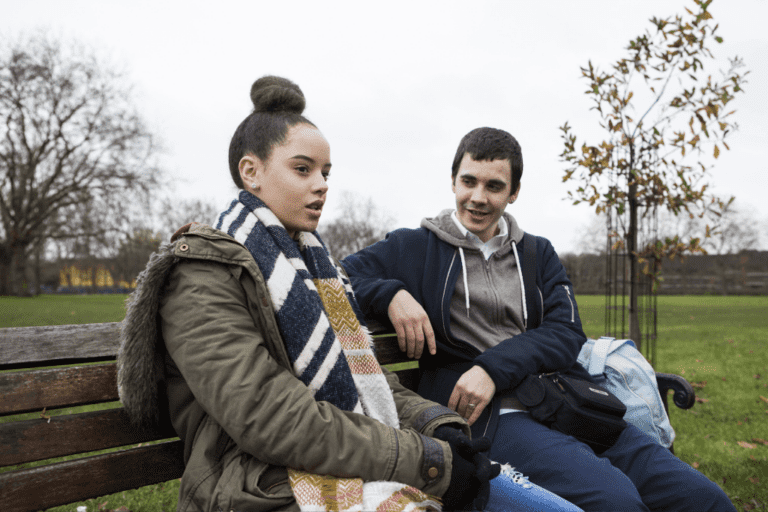 a person and person sitting on a bench