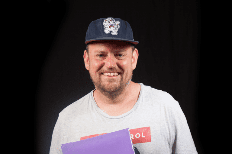 a man smiling with a hat
