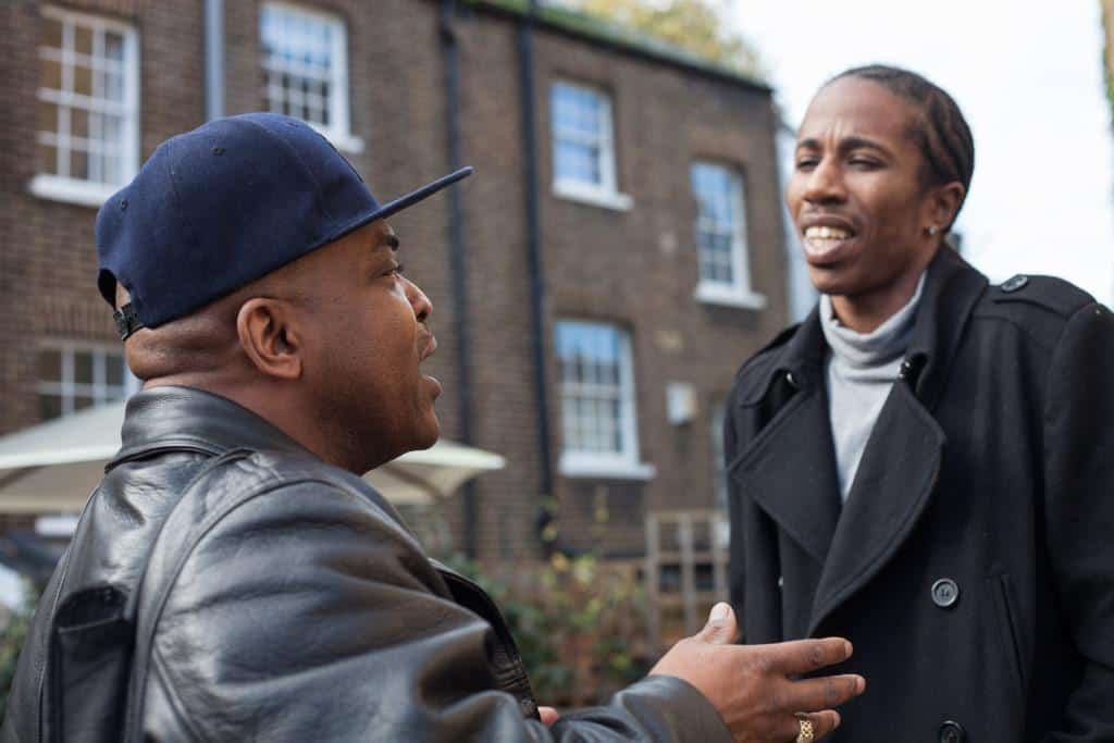 a man in a cap talking to another man