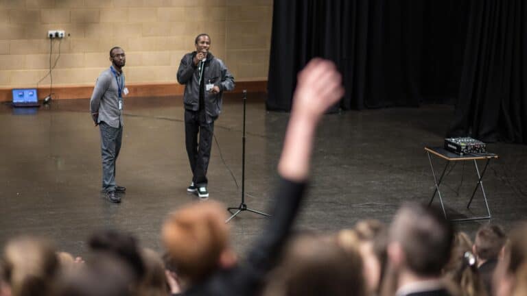 two men on a stage with a large crowd watching