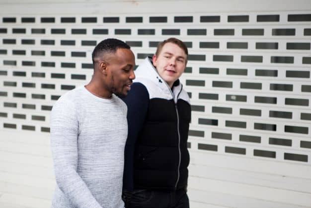 a couple of men standing in front of a garage door