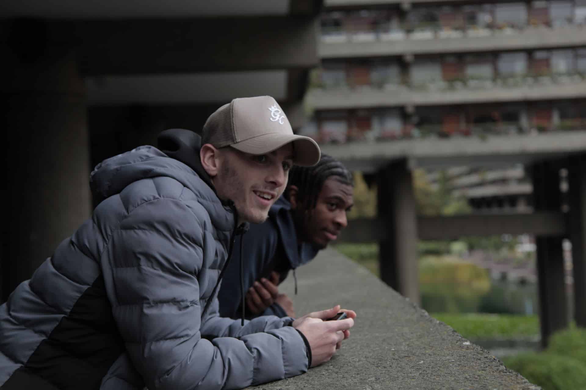 a couple of men leaning against a ledge