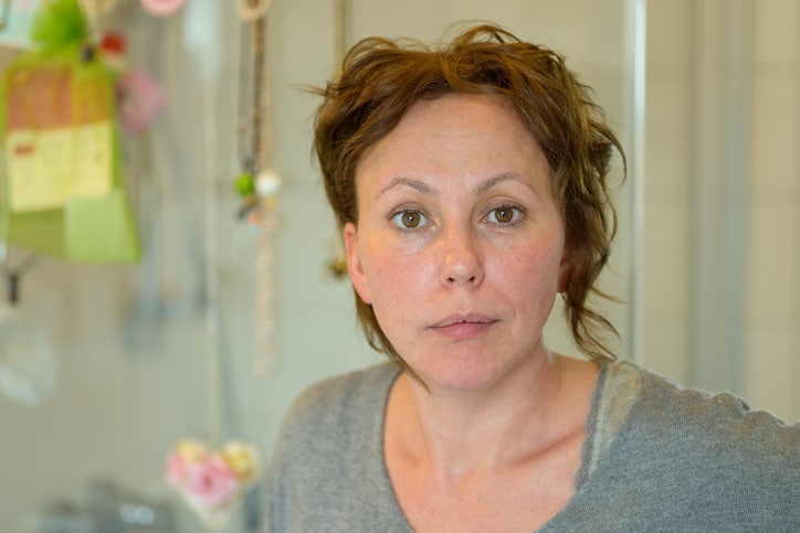 Attractive Hispanic woman looking thoughtfully with a serious expression indoors at home in a close up portrait