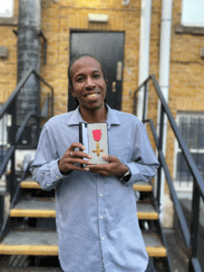 Photograph of Junior holding his award.