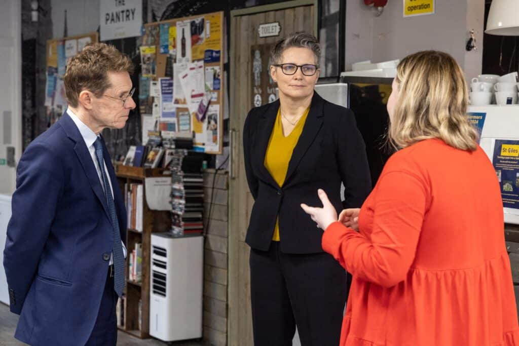 Photograph of Andy Street and Tracey Burleystood talking with a member of in St Giles Midlands office.