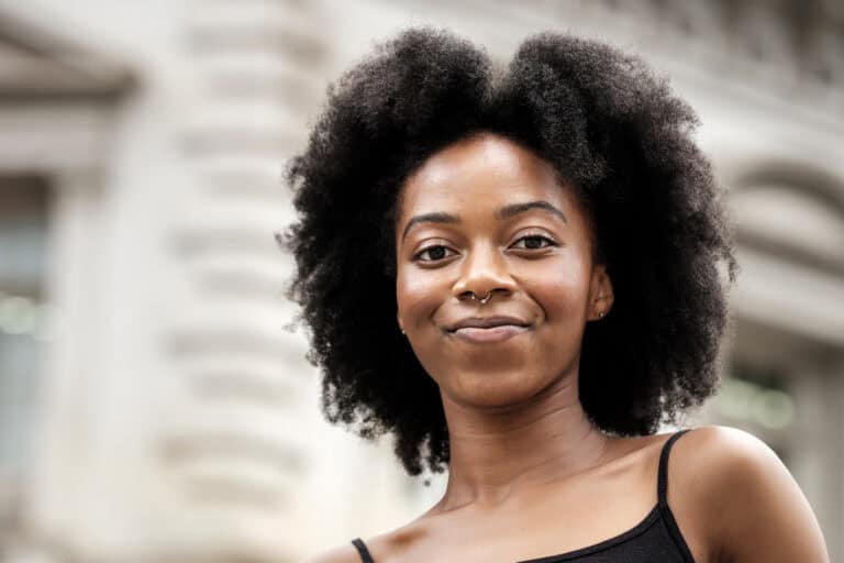 Head shot of happy global majority woman mid 20s in urban setting