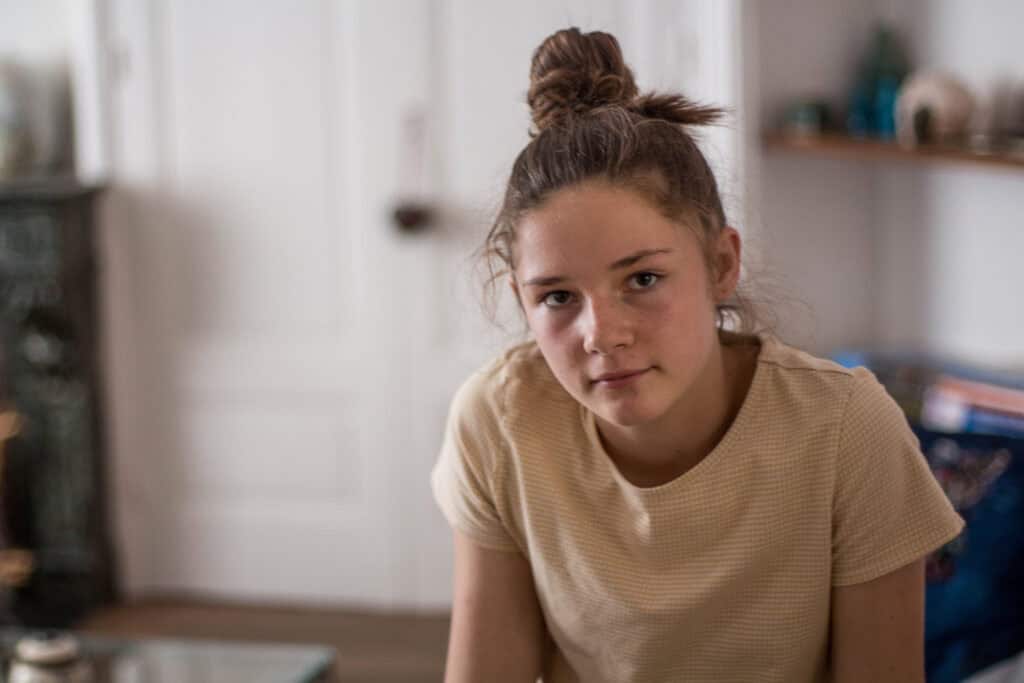 A thoughtful teenager in a calm and shabby interior