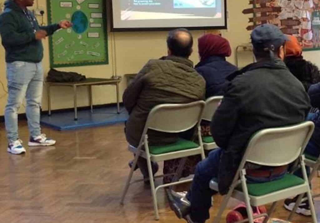 Parent Carer Text Image A group of people sitting in chairs in front of a projector screen