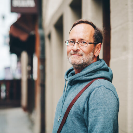Outdoor portrait of 50 year old man wearing blue hoody and eyeglasses
