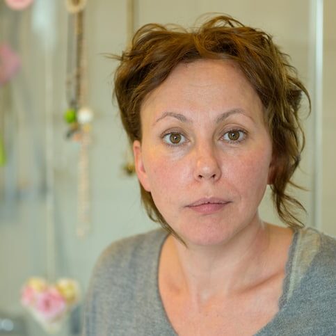 Attractive Hispanic woman looking thoughtfully with a serious expression indoors at home in a close up portrait